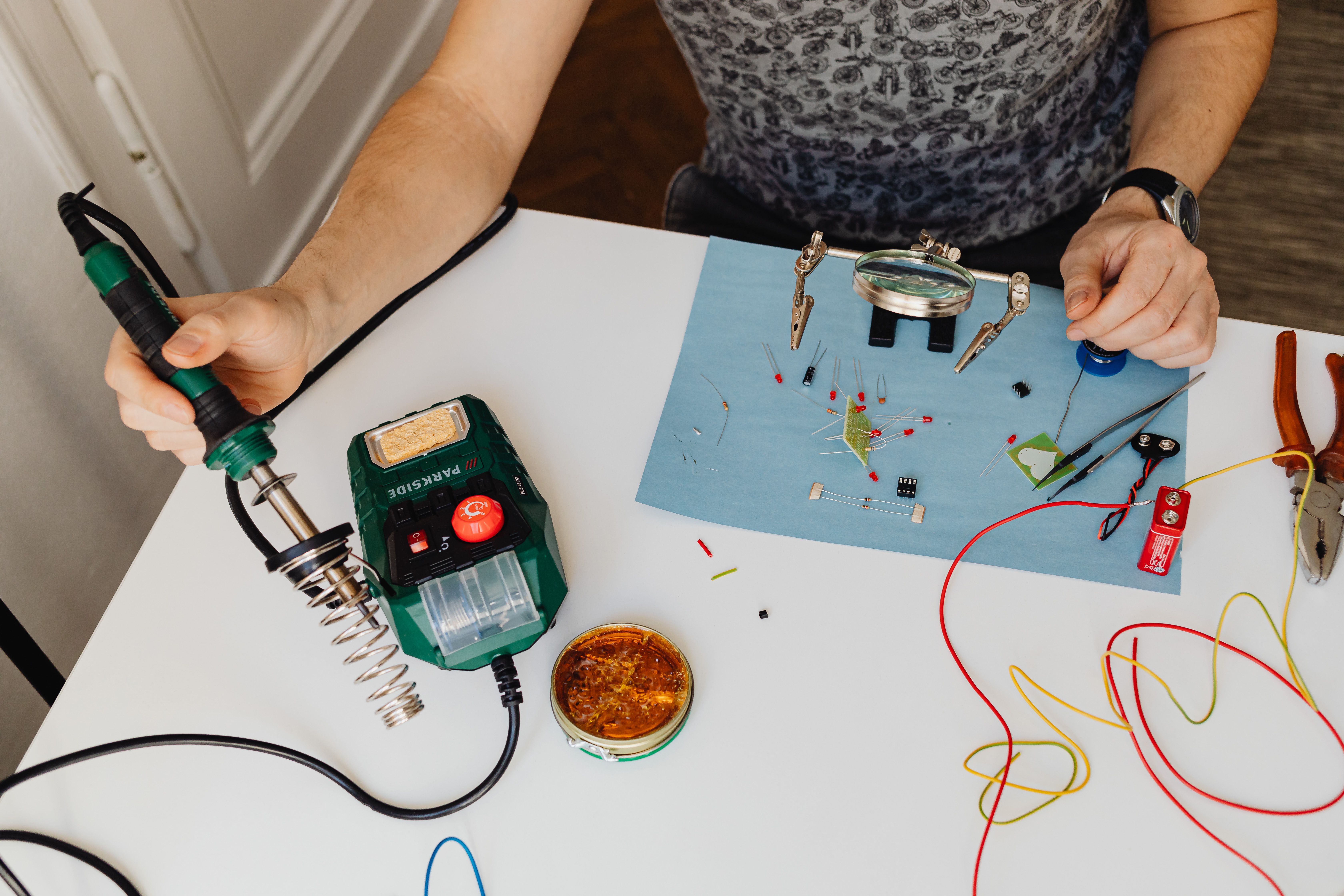 Person soldering electronic components on a workbench